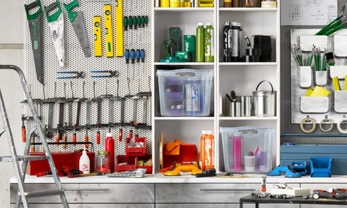 Werkzeugwand mit Sägen, Wasserwaagen, Schraubendrehern und Zangen. Regale mit Behältern und Flaschen. Ein perfektes Ideen Garage Ordnungssystem.