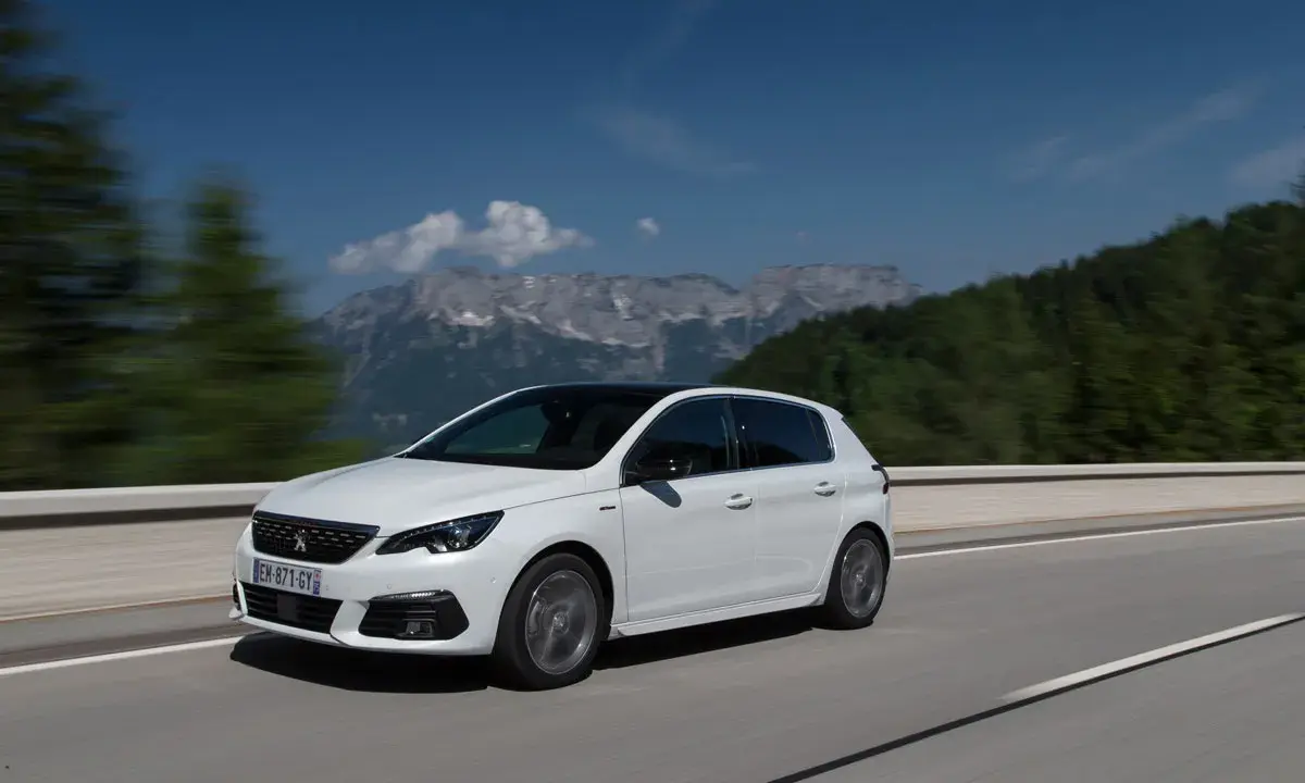 Blanco Peugeot 308 con motor 1.5 BlueHDi 100cv en carretera, con montañas al fondo. ¿Problemas?
