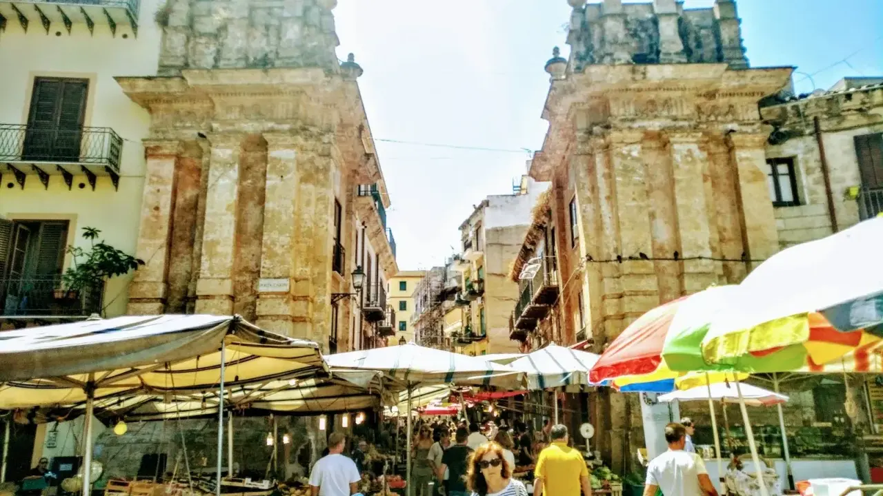 Mercato vivace a Palermo, tra bancarelle colorate e antiche architetture. Un'ottima idea per le cose da fare a Palermo, tra sapori e storia.