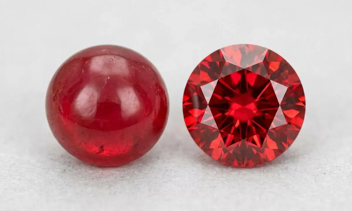 Due pietre rosse brillanti, una liscia e sferica, l'altra sfaccettata e scintillante: il minerale del rubino in due forme.