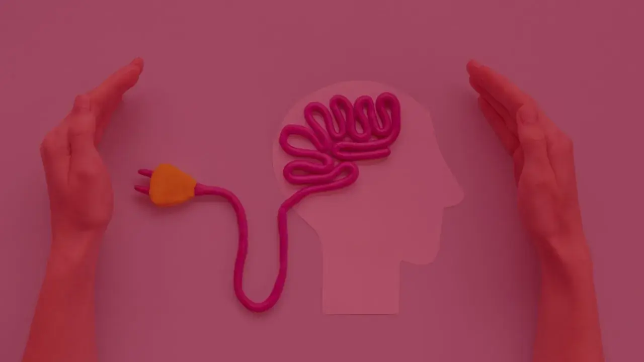 Dwie dłonie otaczają profil głowy z plastelinowym mózgiem podłączonym do wtyczki. Czy studia psychologiczne są trudne?