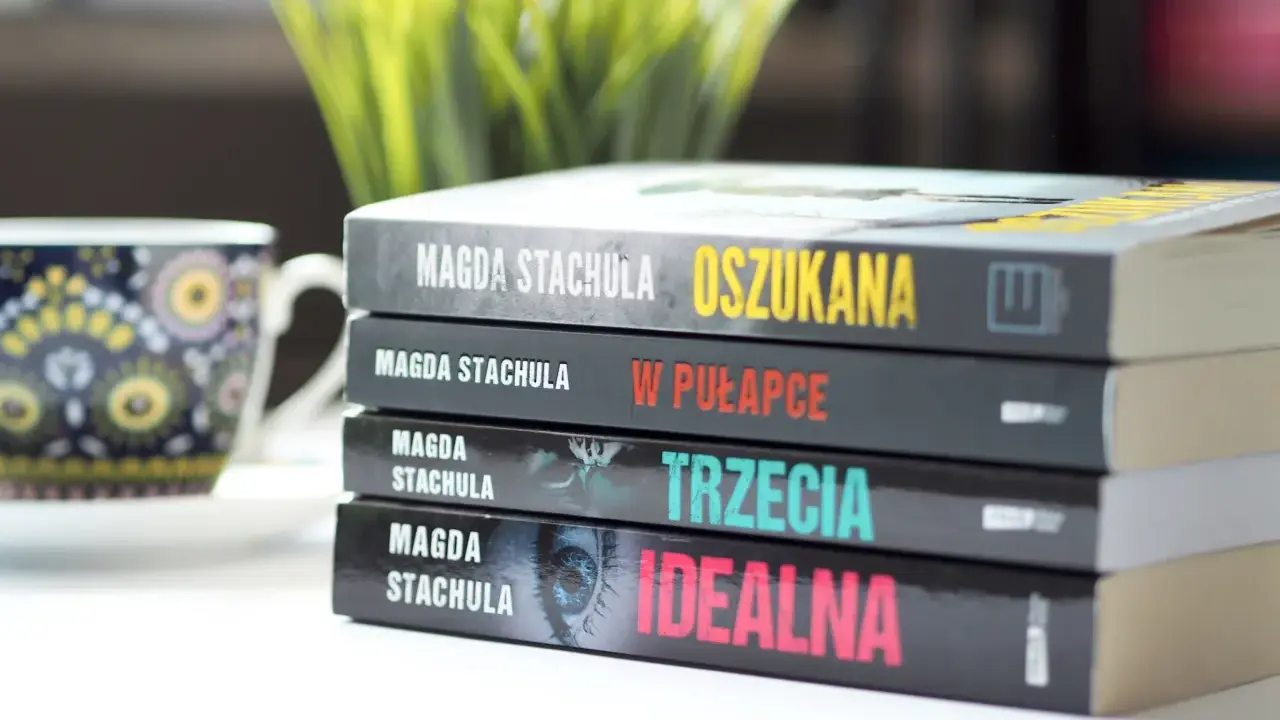 Kolejność czytania książek Magdy Stachuli: "Oszukana", "W pułapce", "Trzecia", "Idealna". Obok filiżanka.