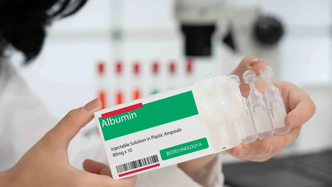 Ręce trzymają opakowanie z napisem "Albumin". To zastrzyk, który może pomóc w leczeniu.