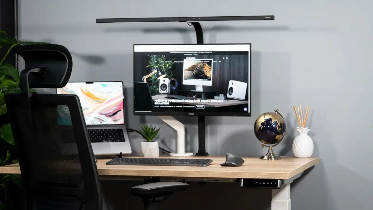 Bureau moderne avec un écran ergonomique, un ordinateur portable et une chaise de bureau.