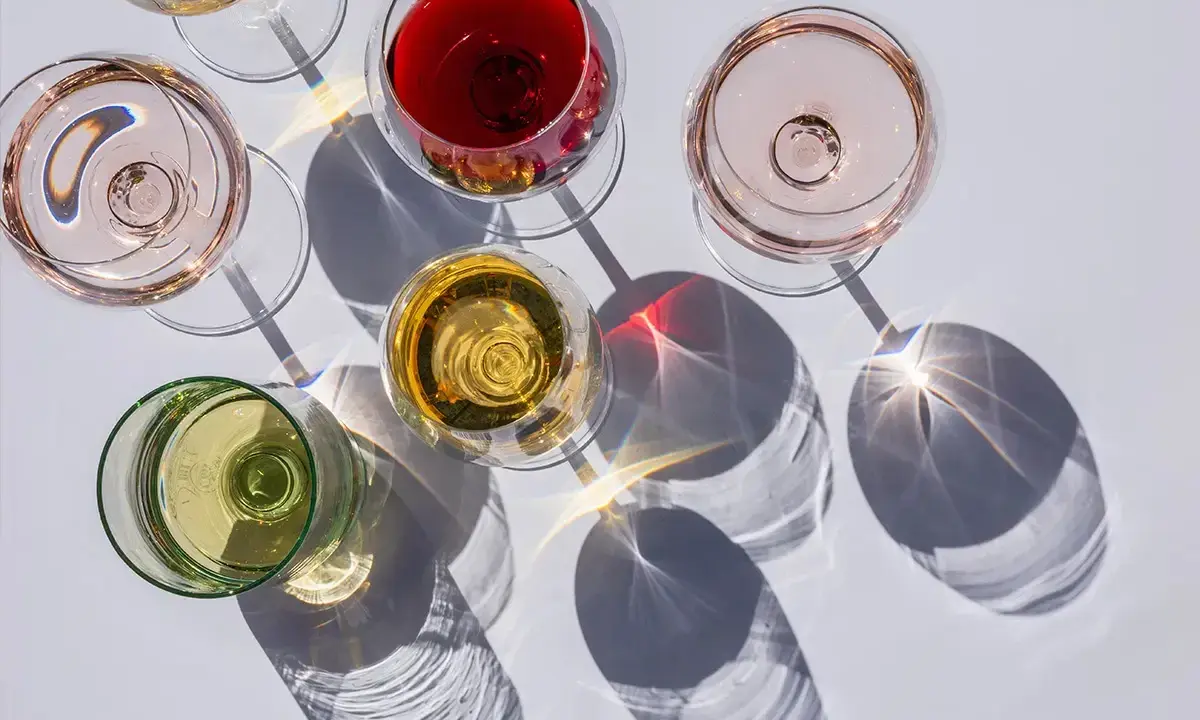 Fünf Gläser Wein in verschiedenen Farben, darunter Rot, Rosé und Weiß. Die Frage: ist alkoholfreier Wein wirklich alkoholfrei?