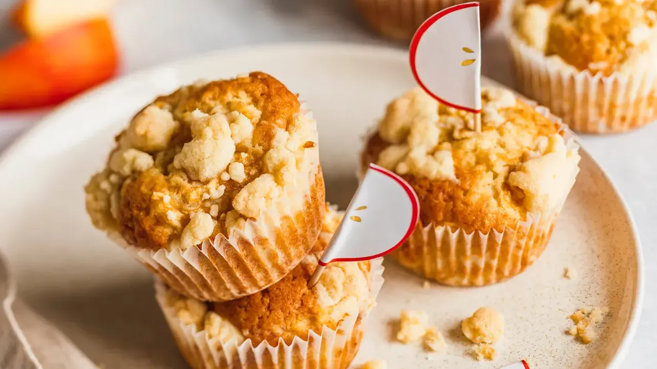 Saftige apfelmus muffins mit Streuseln, dekoriert mit kleinen Apfel-Ansteckern. Ein Genuss für jeden Apfelliebhaber!