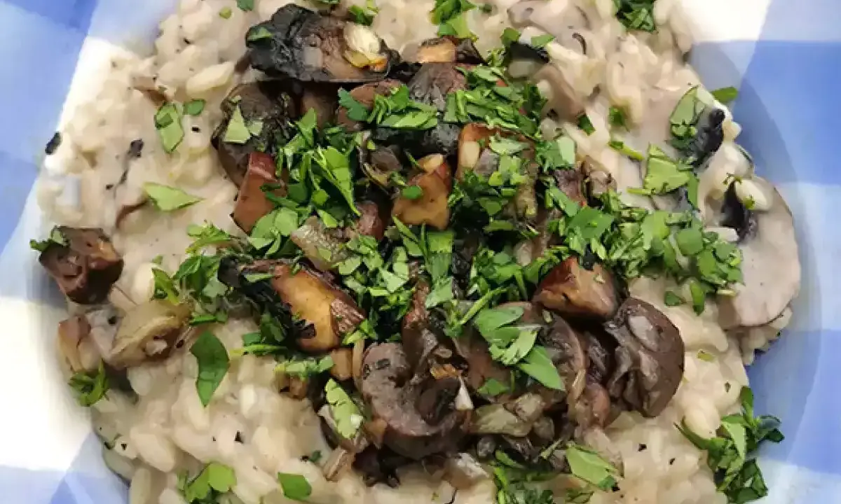 Delicioso risotto de setas cremoso, coronado con champiñones salteados y perejil fresco picado.