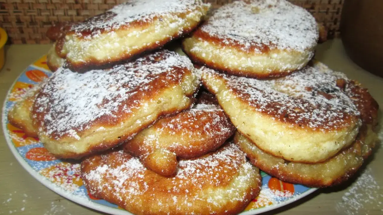 Stos puszystych placków z jabłkami, posypanych cukrem pudrem. Idealne na najprostszy przepis na placki z jabłkami.