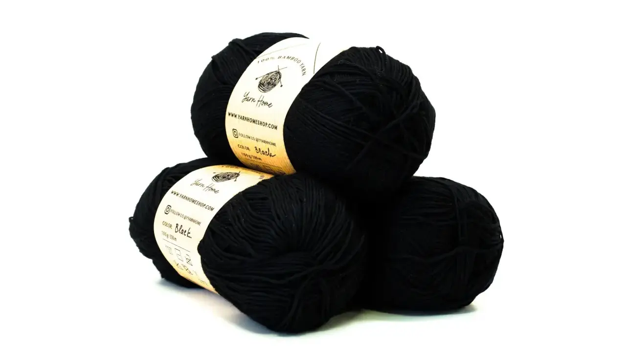 Trzy kłębki czarnej, delikatnej włóczki **alize bamboo fine** od Yarn Home, idealne do tworzenia miękkich dzianin.