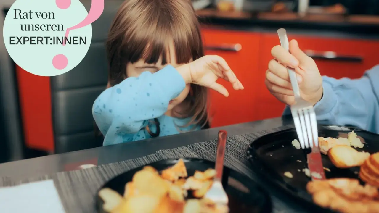 Kind mit blauer Kleidung weint, während es isst. Ein Teller mit Kartoffeln und Fleisch. Hilfe bei picky eater syndrom.