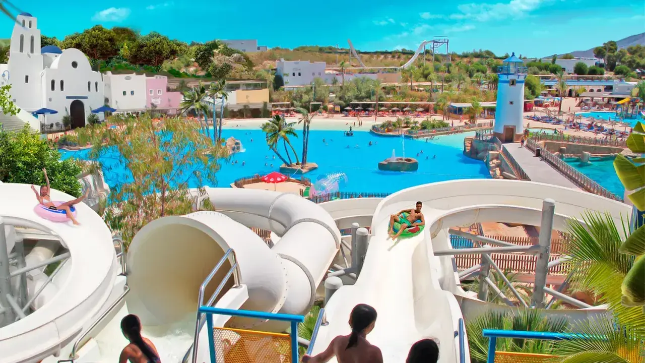 ¡Diversión en el parque acuático Cantabria! Niños disfrutan toboganes y piscina de olas bajo el sol.
