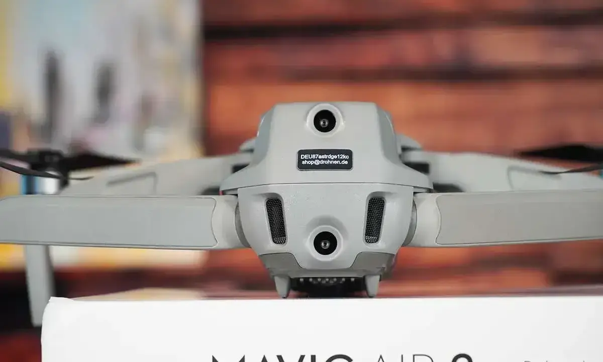 Graue e-id drohne, Mavic Air 2, mit zwei Kameras und Lüftungsschlitzen, steht auf einem Karton.