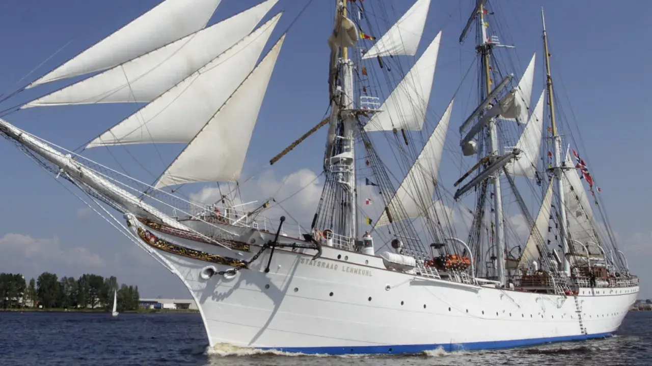 Le Statsraad Lehmkuhl, voilier blanc aux voiles gonflées, navigue fièrement, symbole du **general valor** des marins.