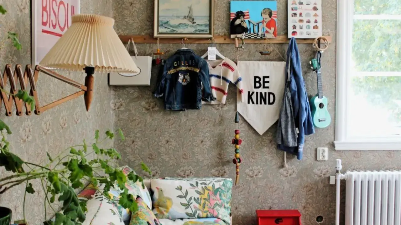 En mysig vrå med barnkläder, en gitarr och en "Be Kind"-flagga, inspirerad av Johanna Bradford blogg.