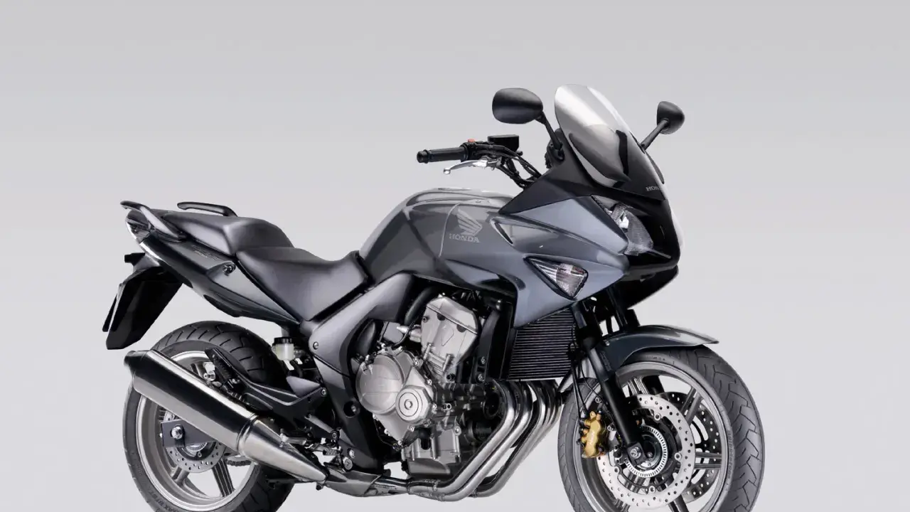 Szary motocykl Honda CBF 600, zgrabny i sportowy, idealny dla osób szukających komfortu i odpowiedniej wysokości siedzenia.