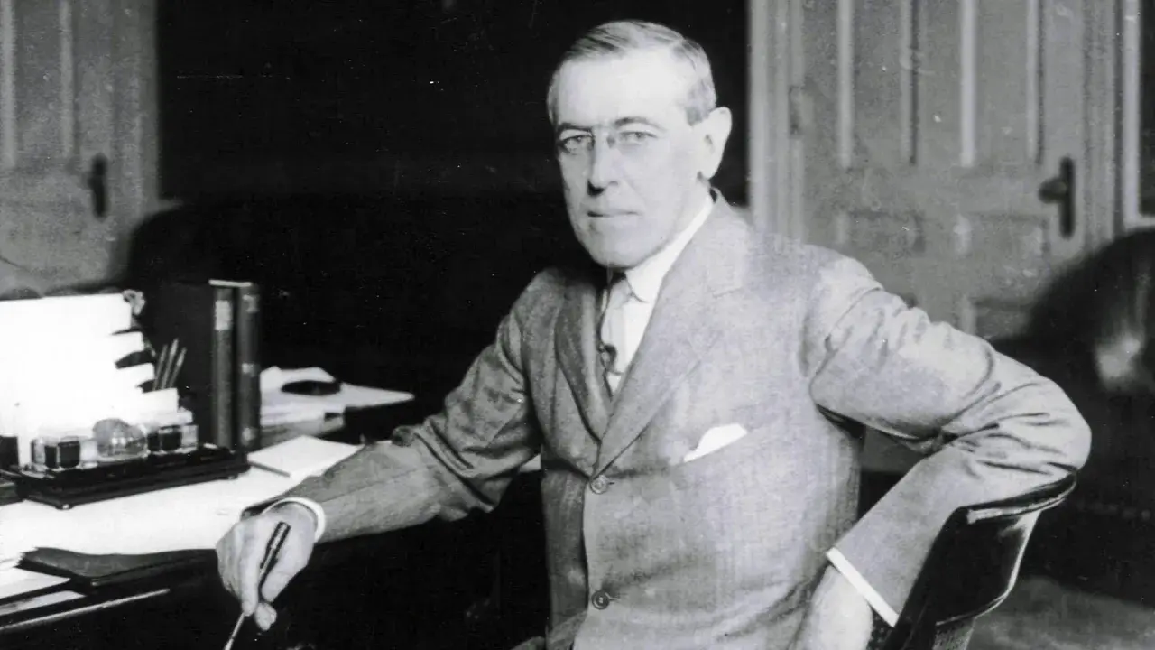 Woodrow Wilson, der den 14-Punkte-Plan zur Friedenssicherung nach dem Ersten Weltkrieg entwickelte, sitzt an seinem Schreibtisch.