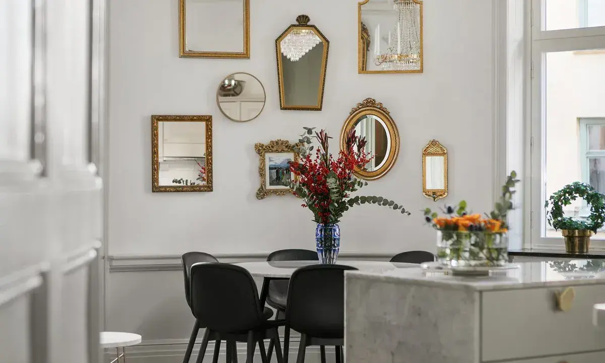 En samling antika speglar ramar in matbordet och skapar en elegant atmosfär.