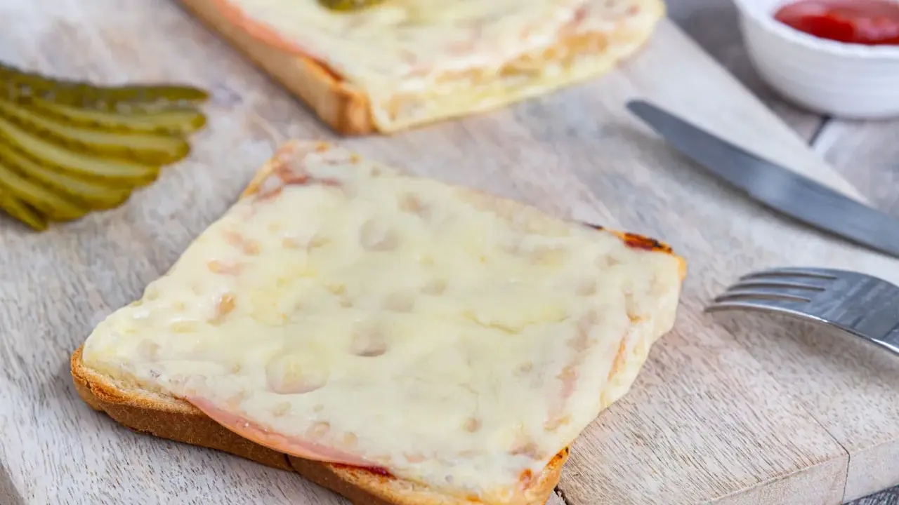 Zwei überbackene Scheiben Brot mit Schinken und Käse, dazu Gewürzgurken. Eine Karlsbader Schnitte, perfekt für den kleinen Hunger.