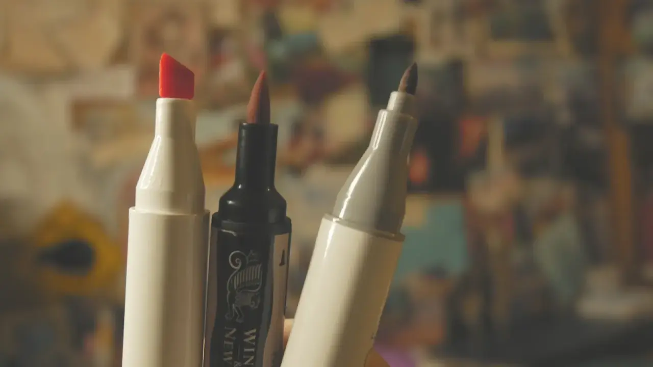 Trzy markery, jeden z czerwoną końcówką, jeden czarny Winsor & Newton i jeden szary, gotowe do tworzenia dzieł sztuki.