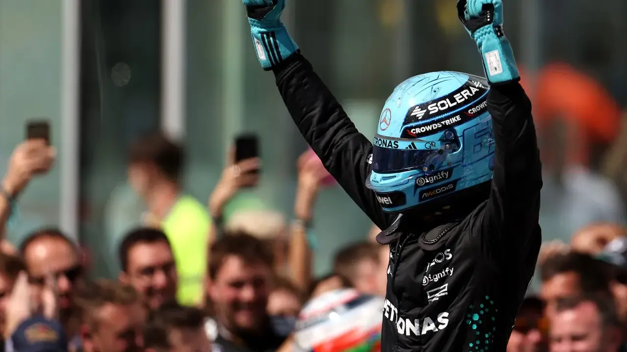 Jubel nach der F1 Qualifying Kanada. Fahrer mit blauem Helm und Handschuhen feiert mit erhobenen Fäusten.