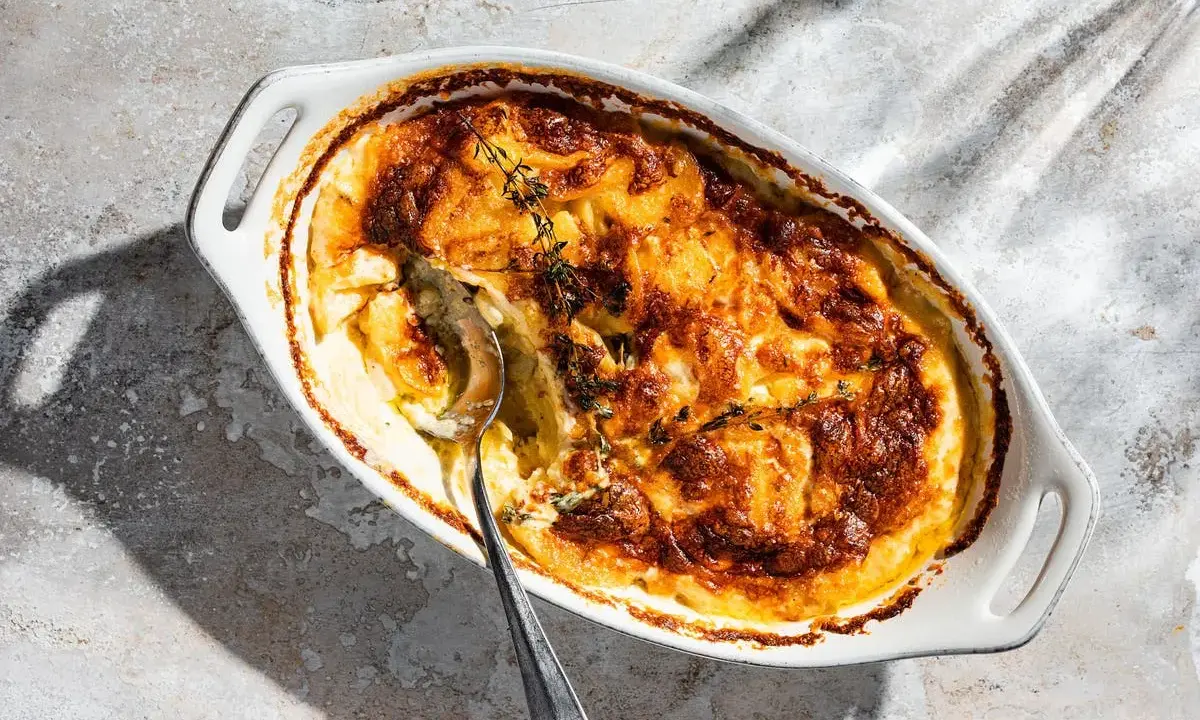 Ein goldbraun gebackener Gratin Dauphinois im ovalen Auflauf, bereit zum Servieren. Dieses Gratin Dauphinois Rezept ist ein Klassiker.