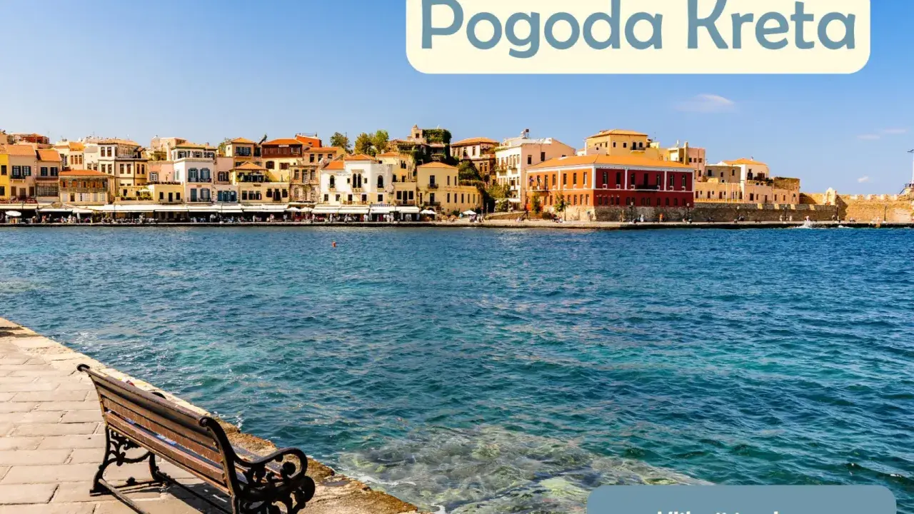 Słoneczna pogoda na Krecie w lipcu. Widok na port z kolorowymi kamienicami i ławką nad turkusową wodą.