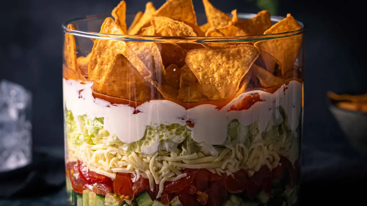 Schichtsalat im Glas: knackige Gurken, Tomaten, Käse, Salat, cremige Soße und Tortilla-Chips. Ein köstlicher nacho salat.