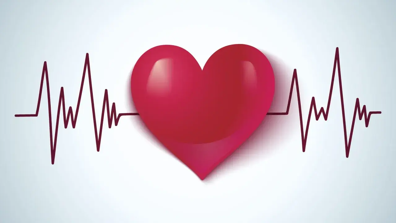Czerwone serce na tle wykresu EKG. Symbolizuje zdrowie, życie i walkę z wadami serca, takimi jak np. VSD.