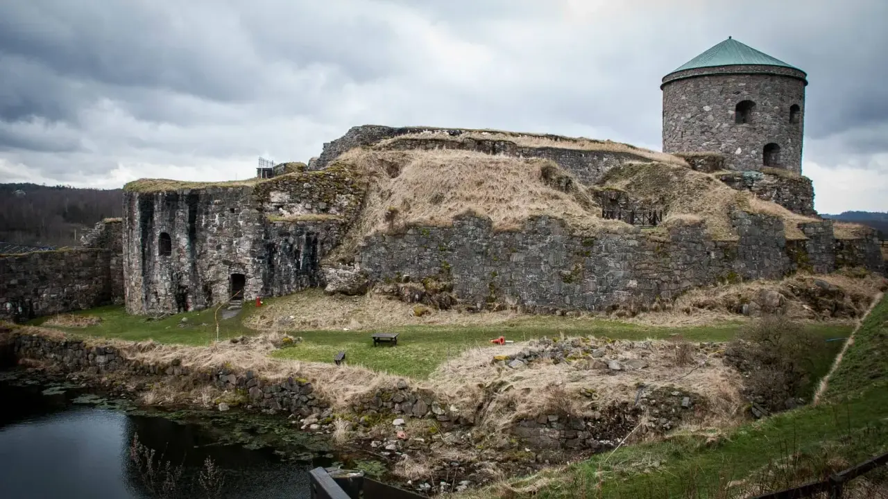 Bohus fästning reser sig stolt mot en molnig himmel, dess stenmurar vittnar om århundraden av historia.