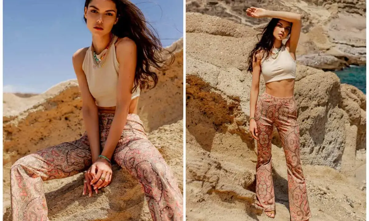 Modelka w spodniach z orientalnym paisley wzorem, pozuje na tle skalistego krajobrazu.
