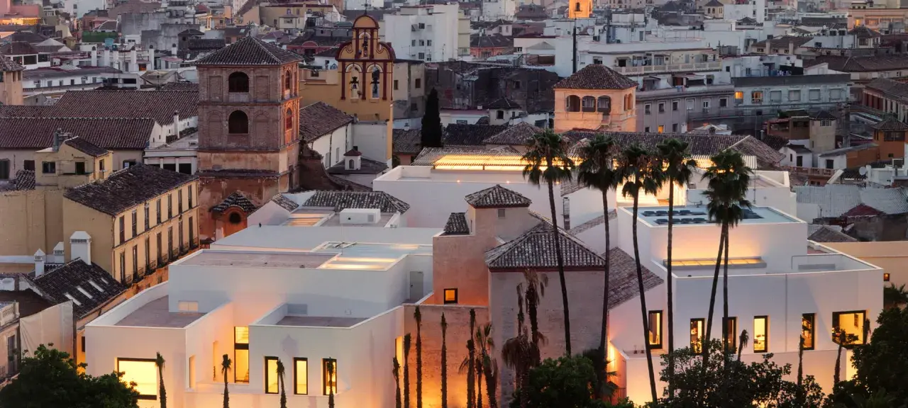 Das Picasso Museum in Spanien, Malaga, mit seinen modernen weißen Gebäuden und Palmen im Abendlicht.
