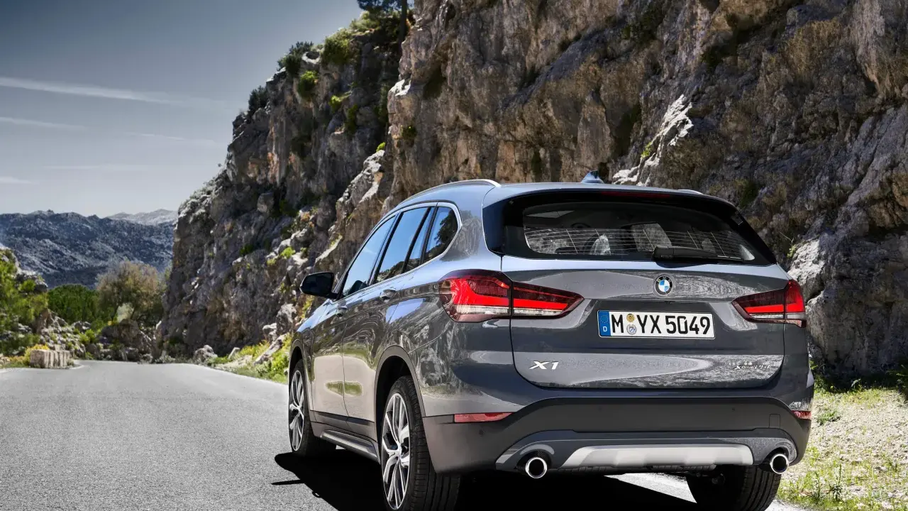 Szary BMW X1 na krętej drodze wśród skał. Sprawdź aktualną bmw x1 cena i wybierz się na przygodę!
