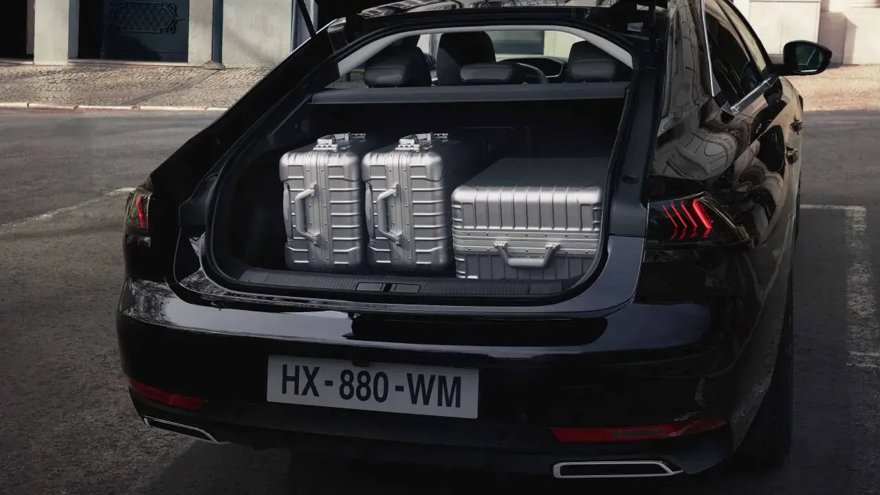 Maletero del Peugeot 508 SW listo para un viaje, con tres maletas plateadas de gran capacidad.