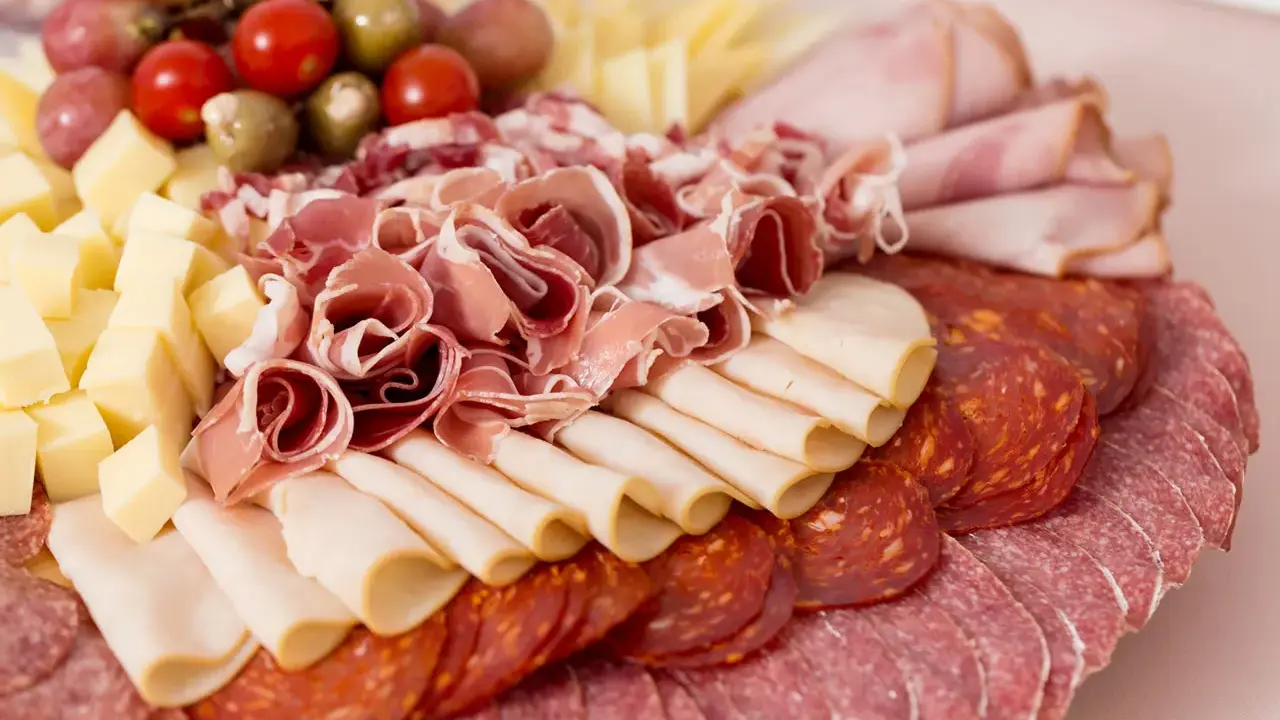 Tagliere ricco di salumi e formaggi, un assaggio di vera cucina emiliana. Prosciutto crudo, salame, mortadella, formaggio a cubetti, pomodorini e olive.