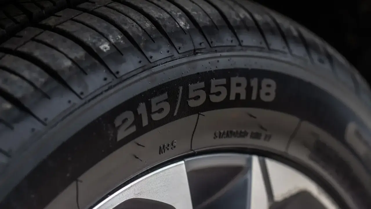 Zbliżenie na oponę z widocznym rozmiarem 215/55R18. Data produkcji opony jest kluczowa dla jej bezpieczeństwa.