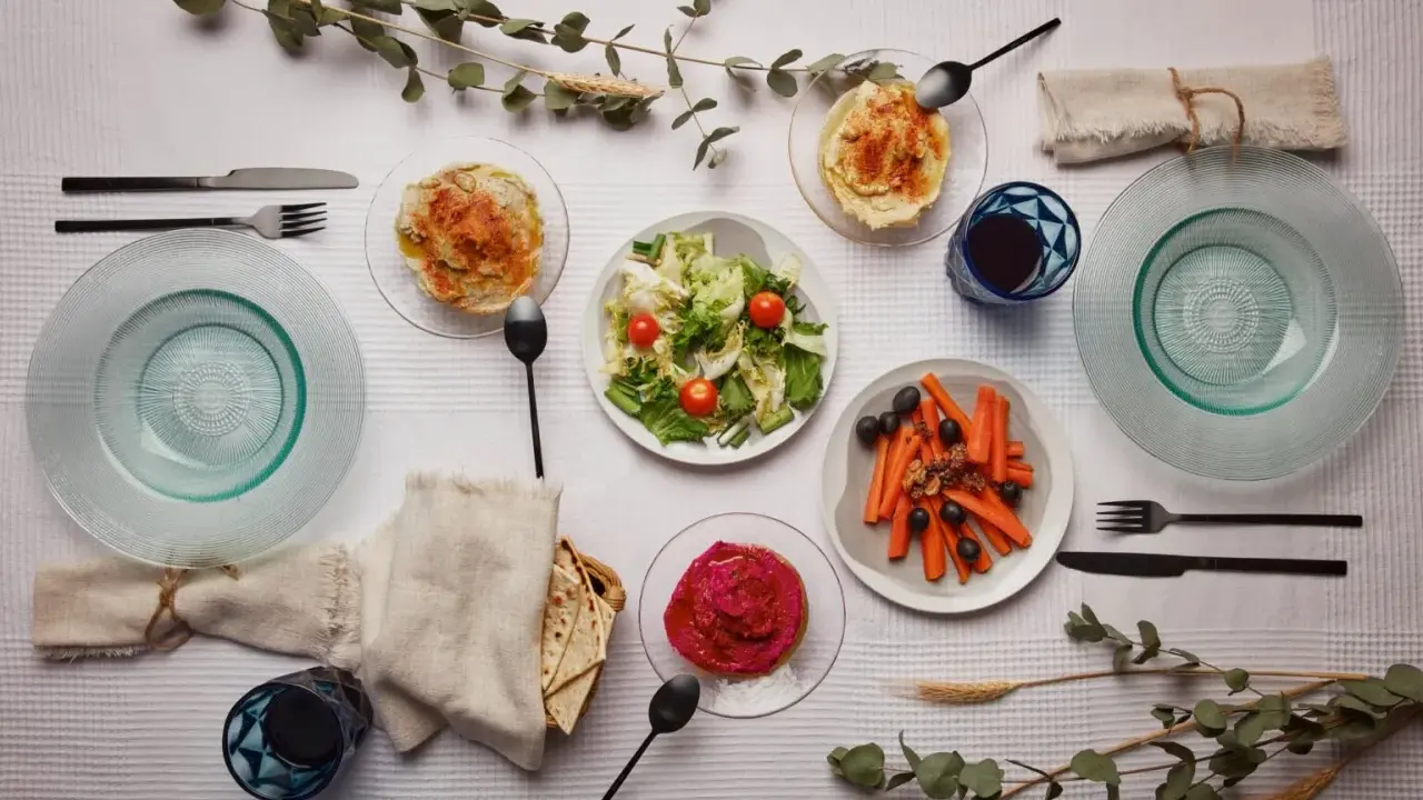 Un repas végétarien servi à l'assiette : houmous, salade, carottes et betterave. Une belle définition du service à l'assiette.