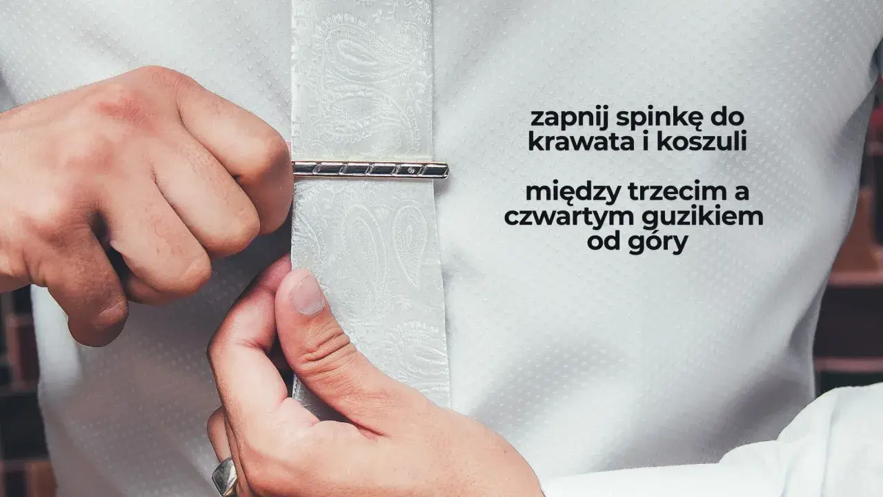 Mężczyzna zapina spinkę do krawata i koszuli między trzecim a czwartym guzikiem od góry. Elegancki sposób na noszenie spinki.