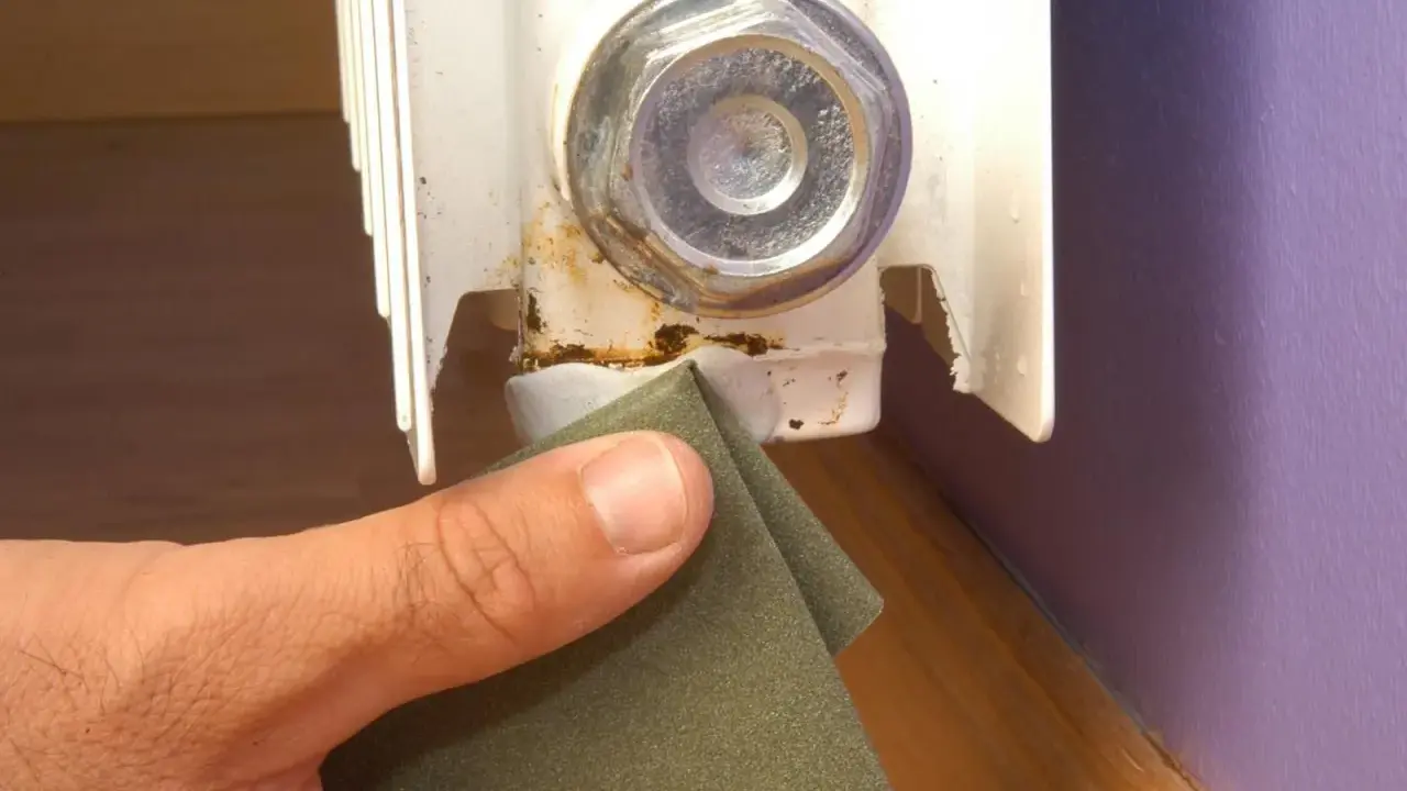 Lijando la zona oxidada de un radiador para prevenir una fuga.