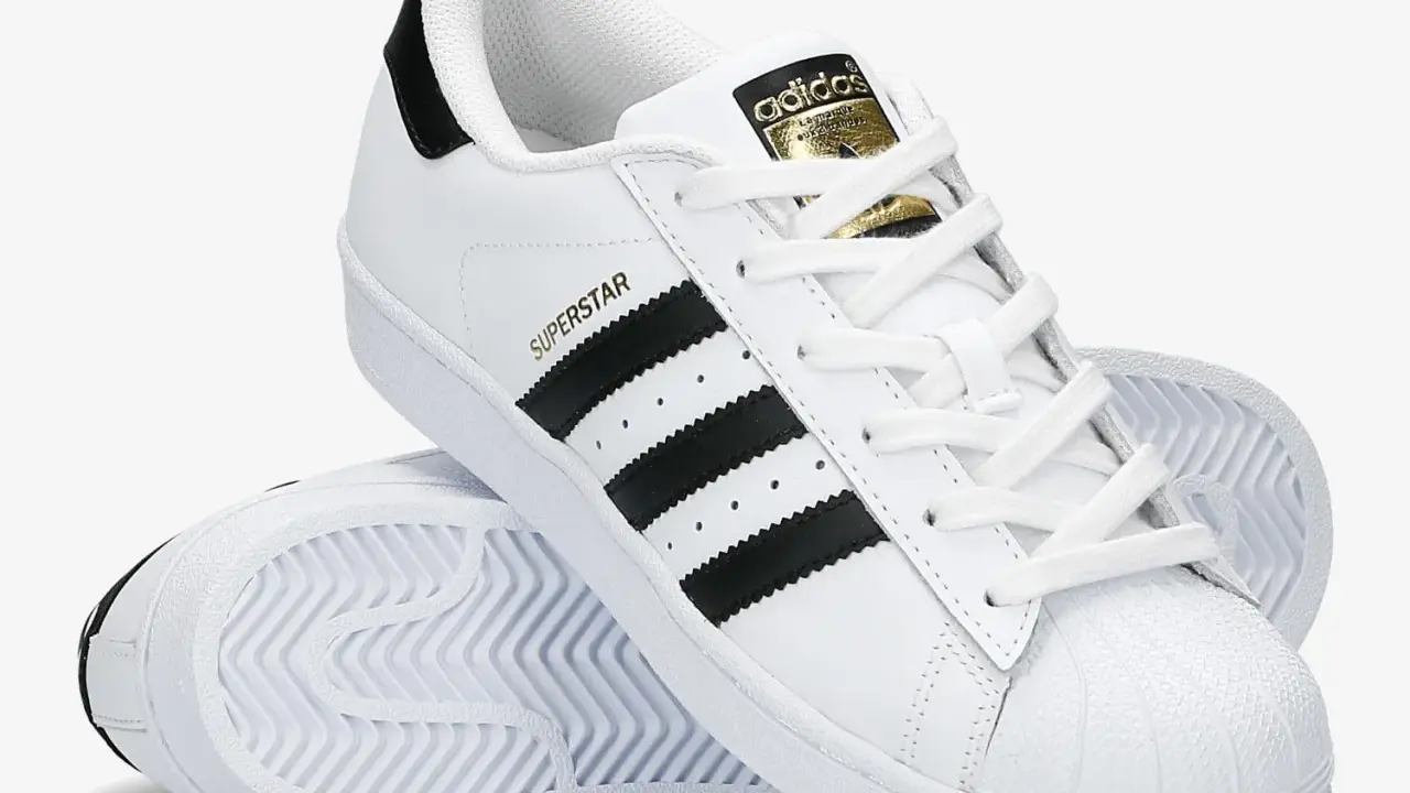 Białe adidas Superstar z czarnymi paskami i złotym logo. Poznaj, czym się różnią modele.