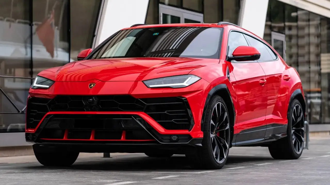 Un imponente Lamborghini Urus rojo, listo para la acción, con su diseño agresivo y llantas negras.