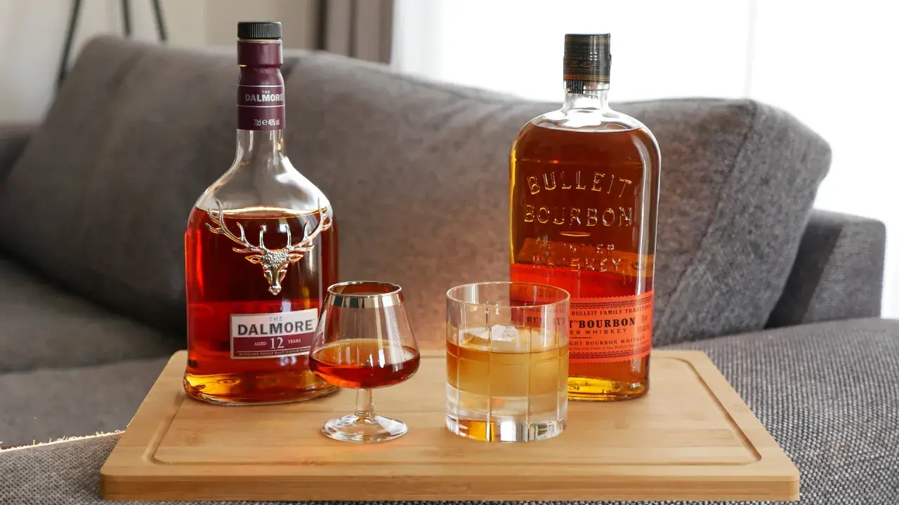 Zwei Flaschen Whiskey, Dalmore und Bulleit Bourbon, und zwei Gläser zeigen die whiskey unterschiede.