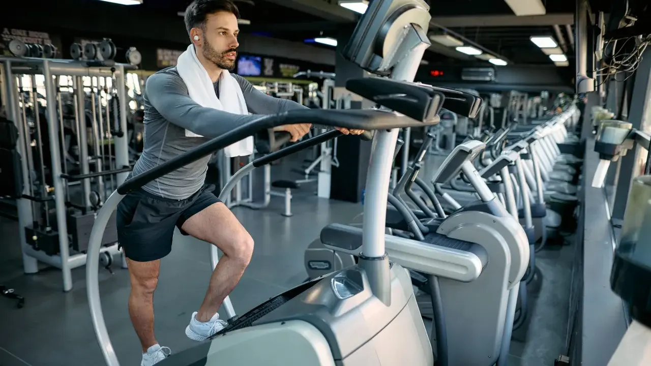 Mann macht ein Stairmaster Workout im Fitnessstudio.