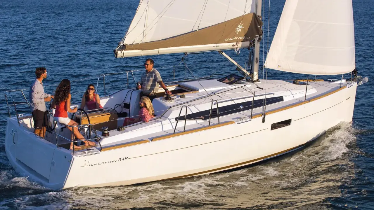 Un voilier Sun Odyssey 349 navigue avec une famille. La fiche technique de ce bateau est idéale pour des vacances en mer.