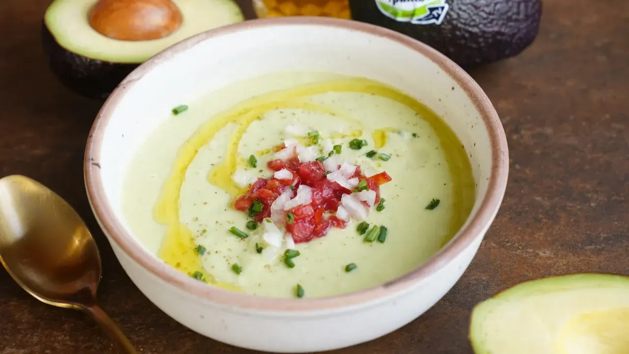 Un cremoso gazpacho de aguacate, coronado con tomate picado, cebolla y cebollino. Un chorrito de aceite de oliva realza su frescura.