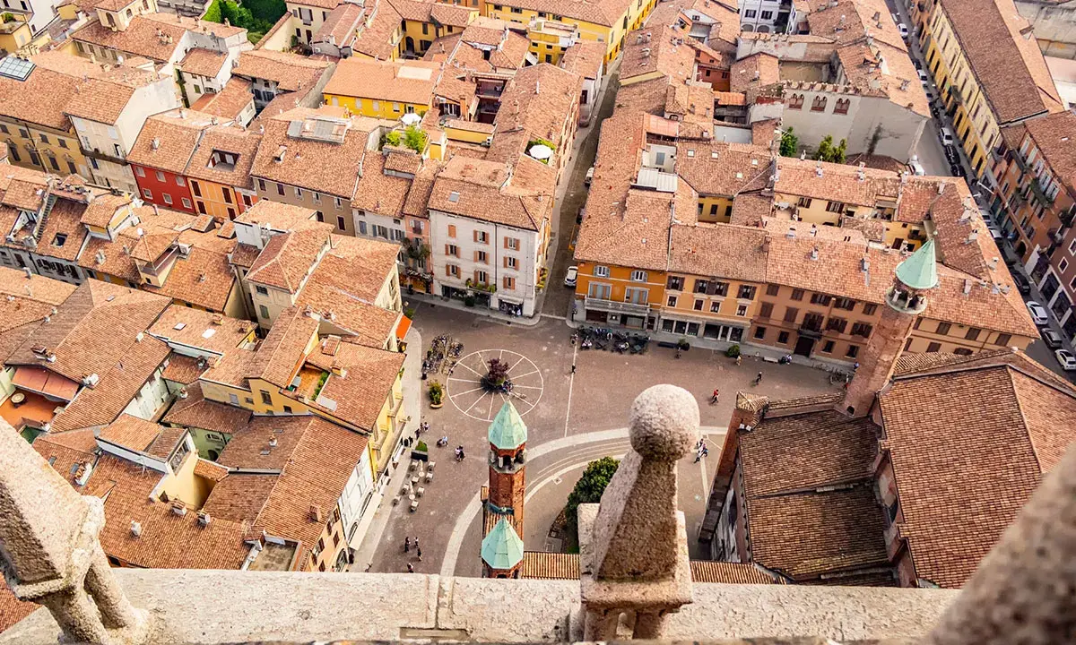 Vista aerea di Cremona: tetti rossi, piazze animate e torri. Un assaggio di cosa vedere a Cremona in un giorno.
