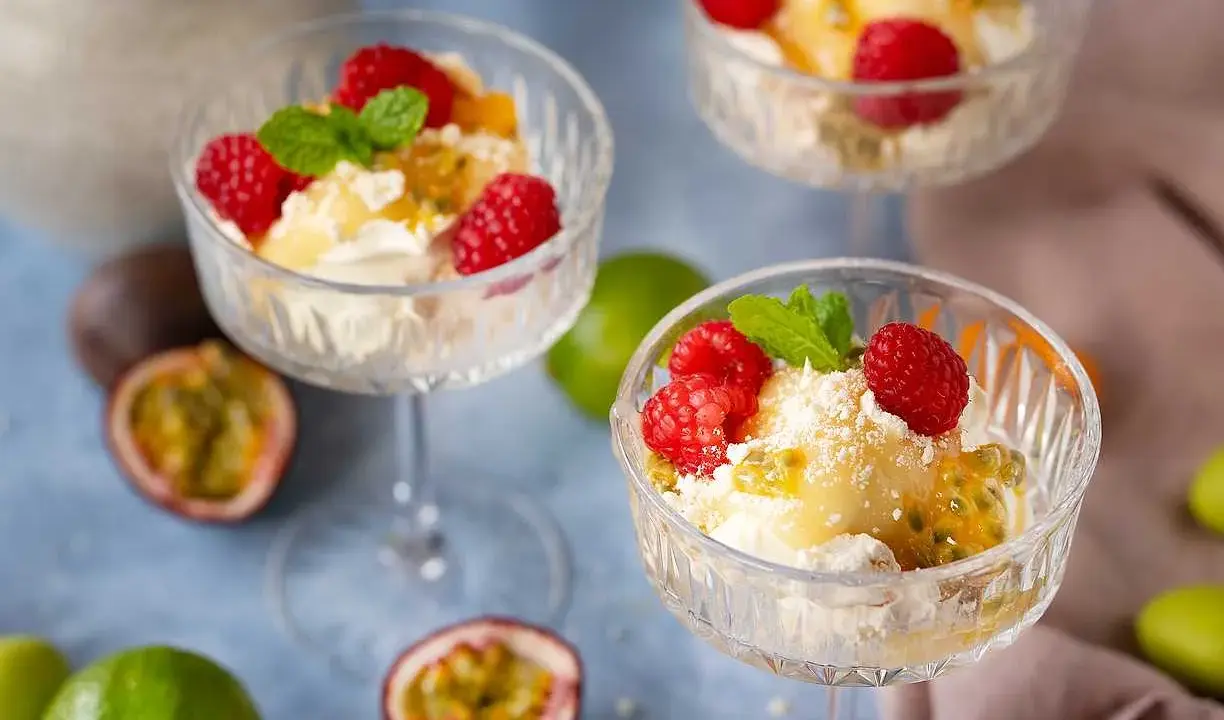 En härlig påskdessert i glas med grädde, passionsfrukt, hallon och mynta. Perfekt för påskfirandet!