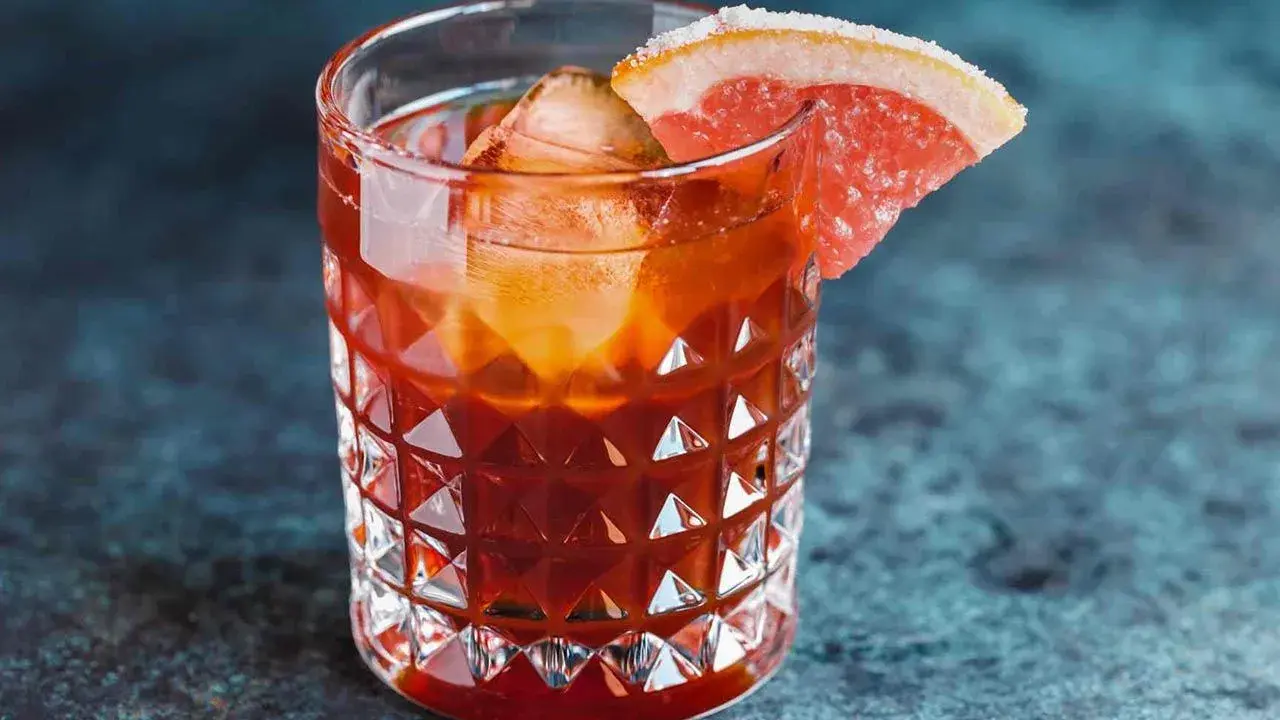 Orzeźwiający koktajl z Jägermeister, lodem i plasterkiem grejpfruta na krawędzi szklanki.