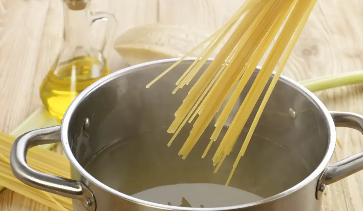 Gotowanie makaronu: jak zagotować wodę w garnku, dodać spaghetti, oliwę i ser.