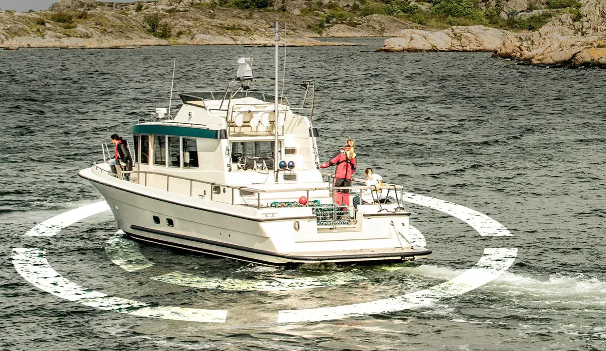 Un bateau navigue en mer, entouré d'une ancre virtuelle. Des personnes sont sur le pont, profitant de la croisière.