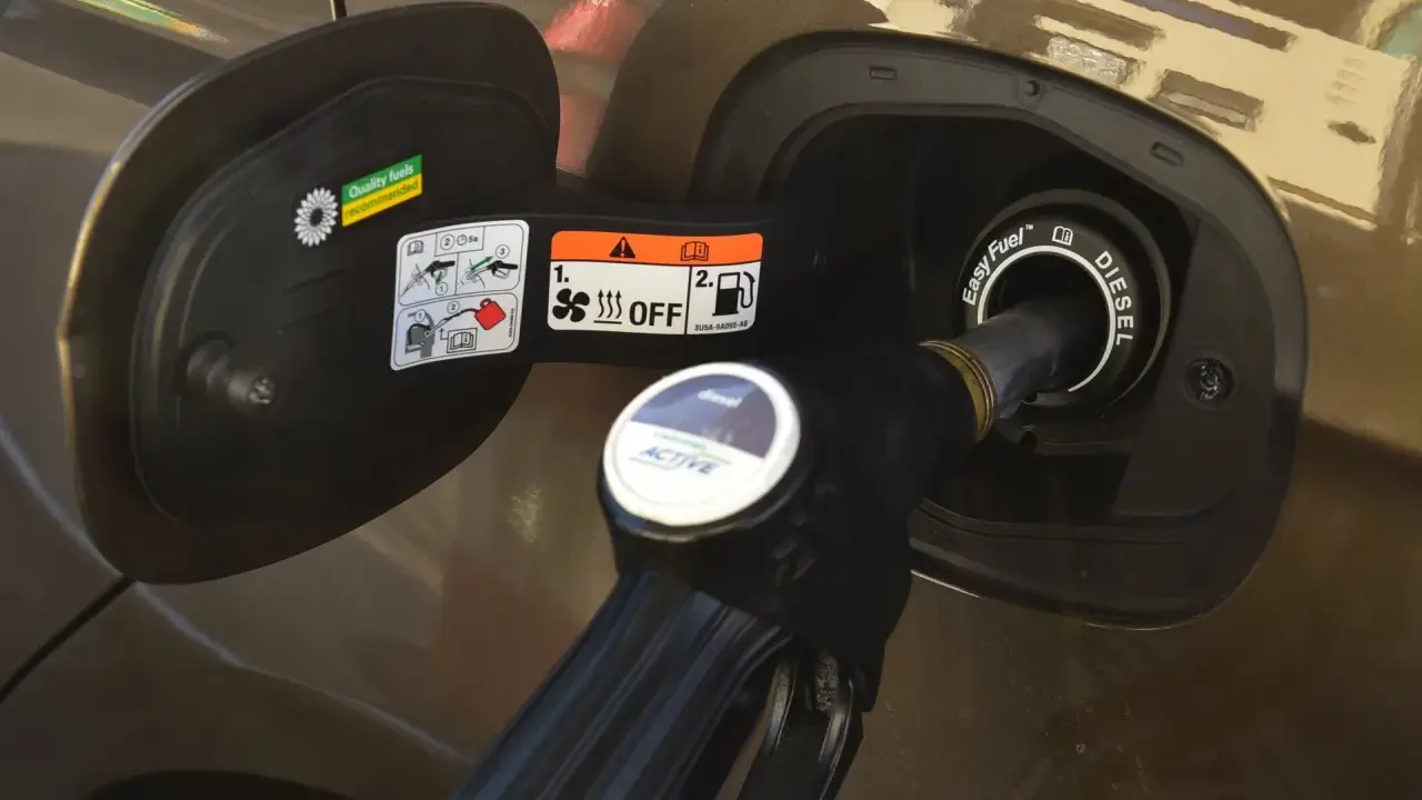 Dysza dystrybutora diesla wlewana do baku. Prosta instrukcja, jak zatankować auto, z oznaczeniami na klapce wlewu paliwa.